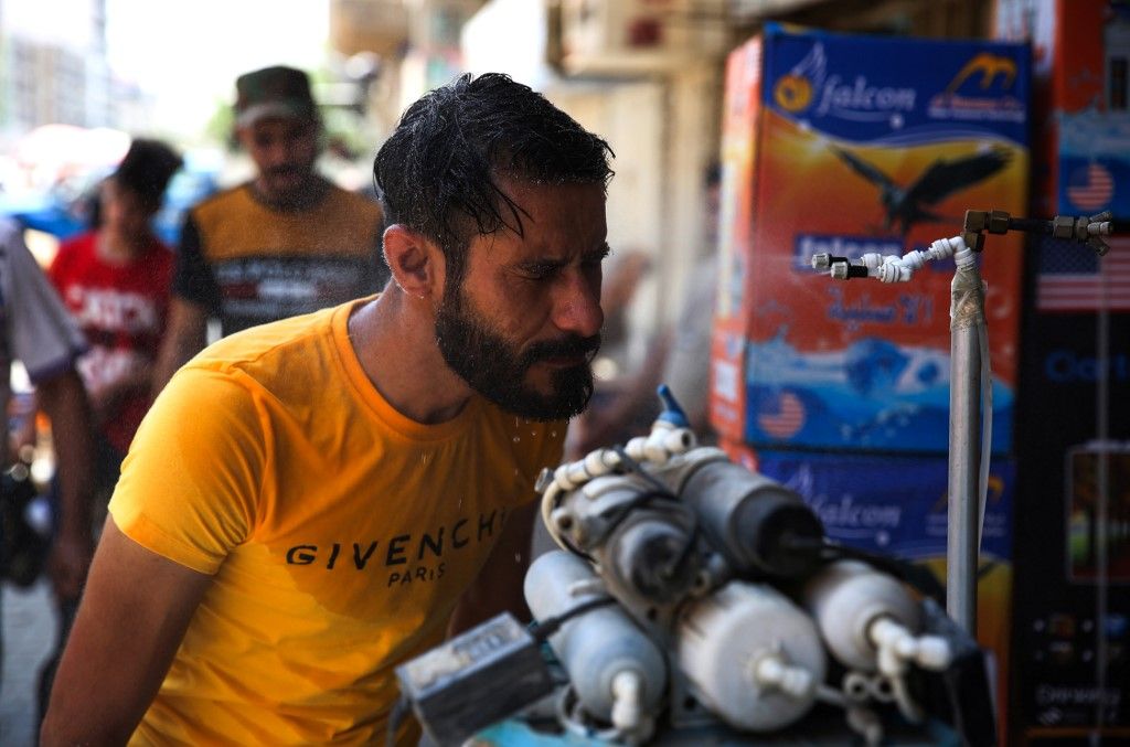 An Iraqi man uses a curbside shower to cool off during a heat wave in the capital Baghdad on June 14, 2019. - As one of the hottest countries in the world with around half of its terrain covered in desert, Iraq is no stranger to stiflingly hot summers. But even by its own standards, this June has been a sizzler averaging a daily 48 degrees Celsius (118 Fahrenheit), compared to around 40 in previous years. (Photo by AHMAD AL-RUBAYE / AFP)