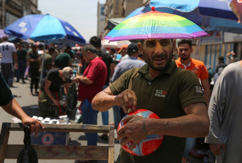 An Iraqi street vendor wears an umbrella-shaped hat to protect his head from the sun during a heat wave in the capital Baghdad on June 14, 2019. - As one of the hottest countries in the world with around half of its terrain covered in desert, Iraq is no stranger to stiflingly hot summers. But even by its own standards, this June has been a sizzler averaging a daily 48 degrees Celsius (118 Fahrenheit), compared to around 40 in previous years. (Photo by AHMAD AL-RUBAYE / AFP)