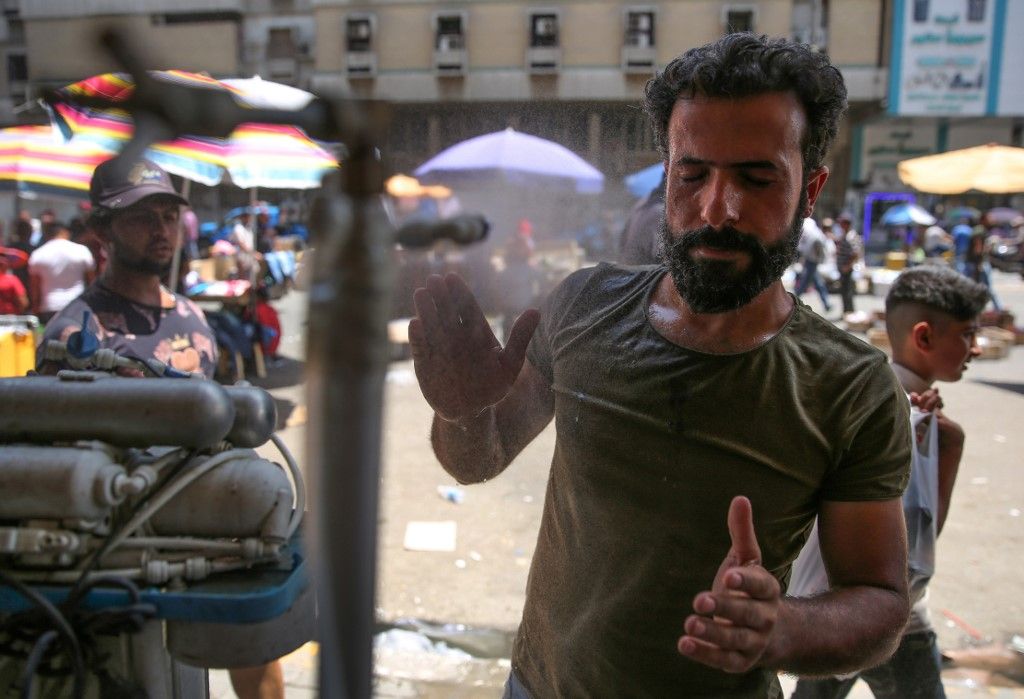 An Iraqi man uses a curbside shower to cool off during a heat wave in the capital Baghdad on June 14, 2019. - As one of the hottest countries in the world with around half of its terrain covered in desert, Iraq is no stranger to stiflingly hot summers. But even by its own standards, this June has been a sizzler averaging a daily 48 degrees Celsius (118 Fahrenheit), compared to around 40 in previous years. (Photo by AHMAD AL-RUBAYE / AFP)